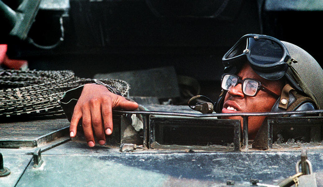 Marine looking out of hatch of armored personnel carrier